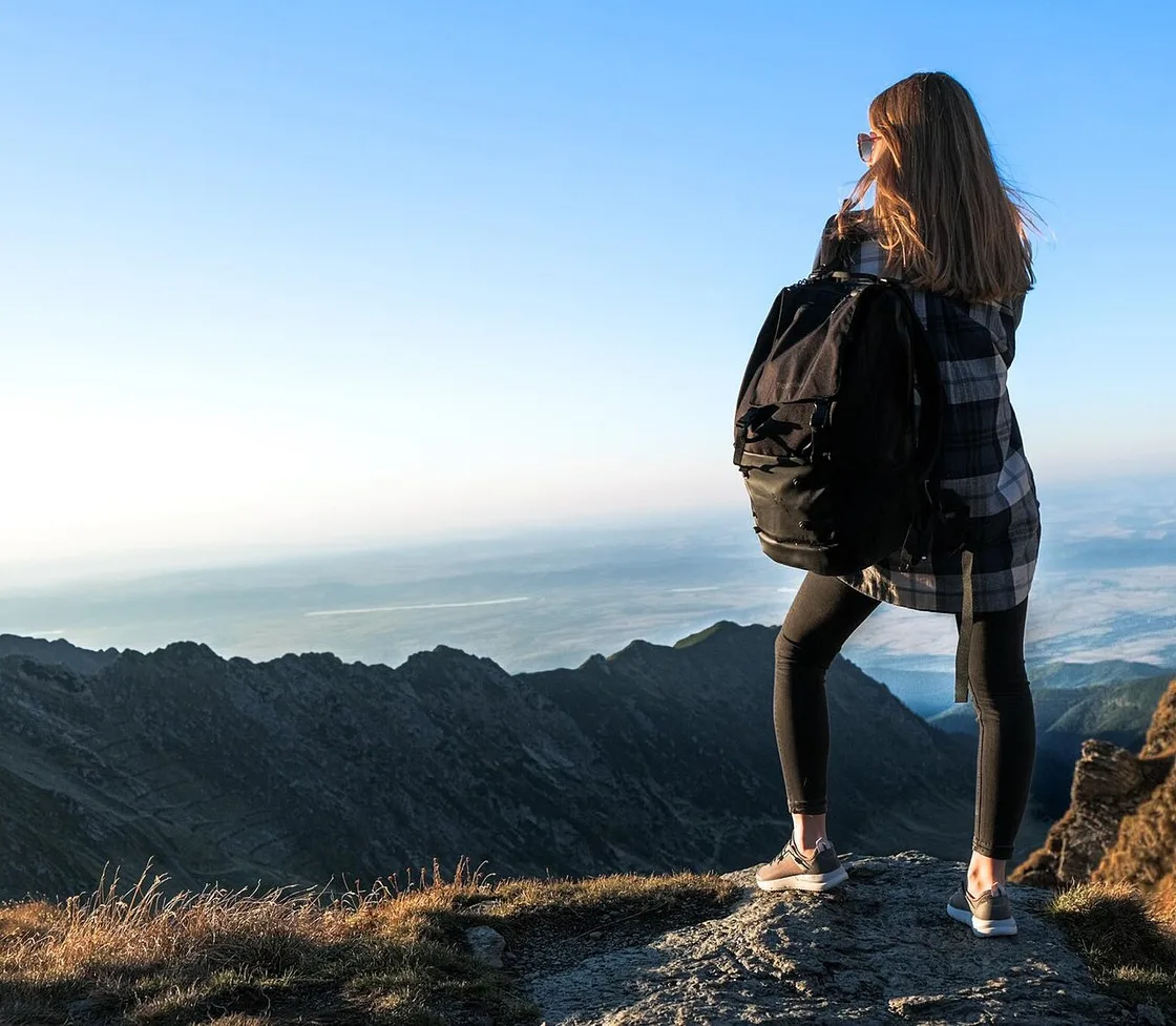 A backpacker looking out over the ridgeline of the Fagaras Mountains in the Carpathians, the kind of remote high terrain where mobile coverage thins on every network