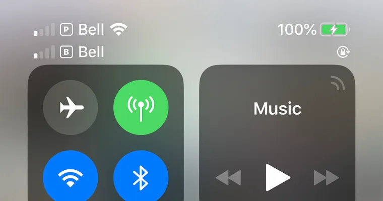 An iPhone status bar showing two signal bars from two lines at once, the dual-SIM setup that lets a home number and a travel eSIM run side by side