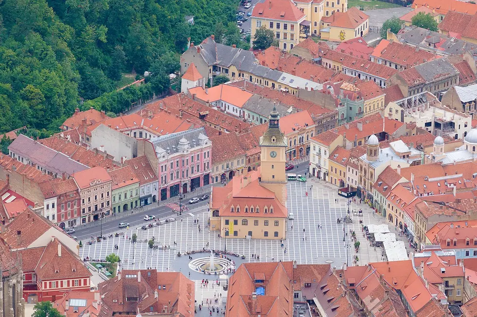Brasov Council Square seen from Tampa mountain, red roofs and cafe terraces around the old town hall