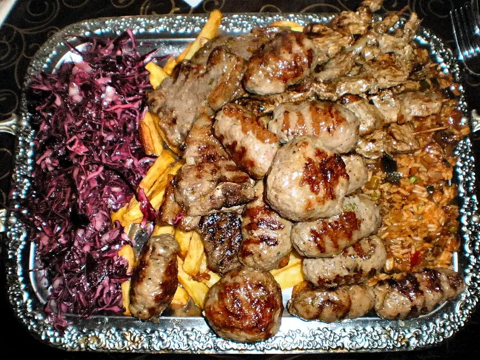 A Romanian mixed grill with mici, grilled skinless minced-meat rolls, served with bread, mustard and sides