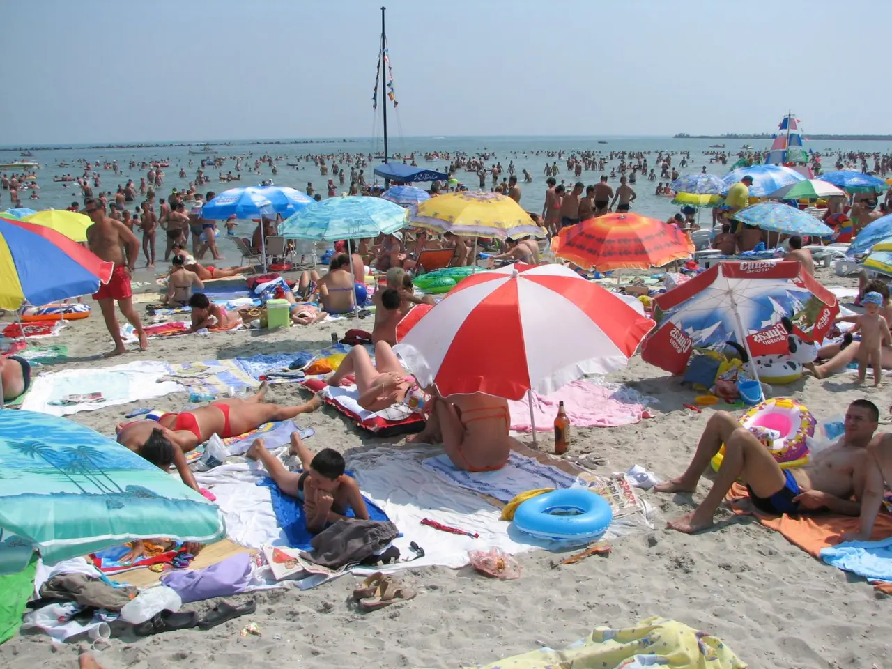 The wide sandy beach at Mamaia on the Black Sea coast in summer, sunbeds and swimmers under a clear sky, Romania beach season in July and August