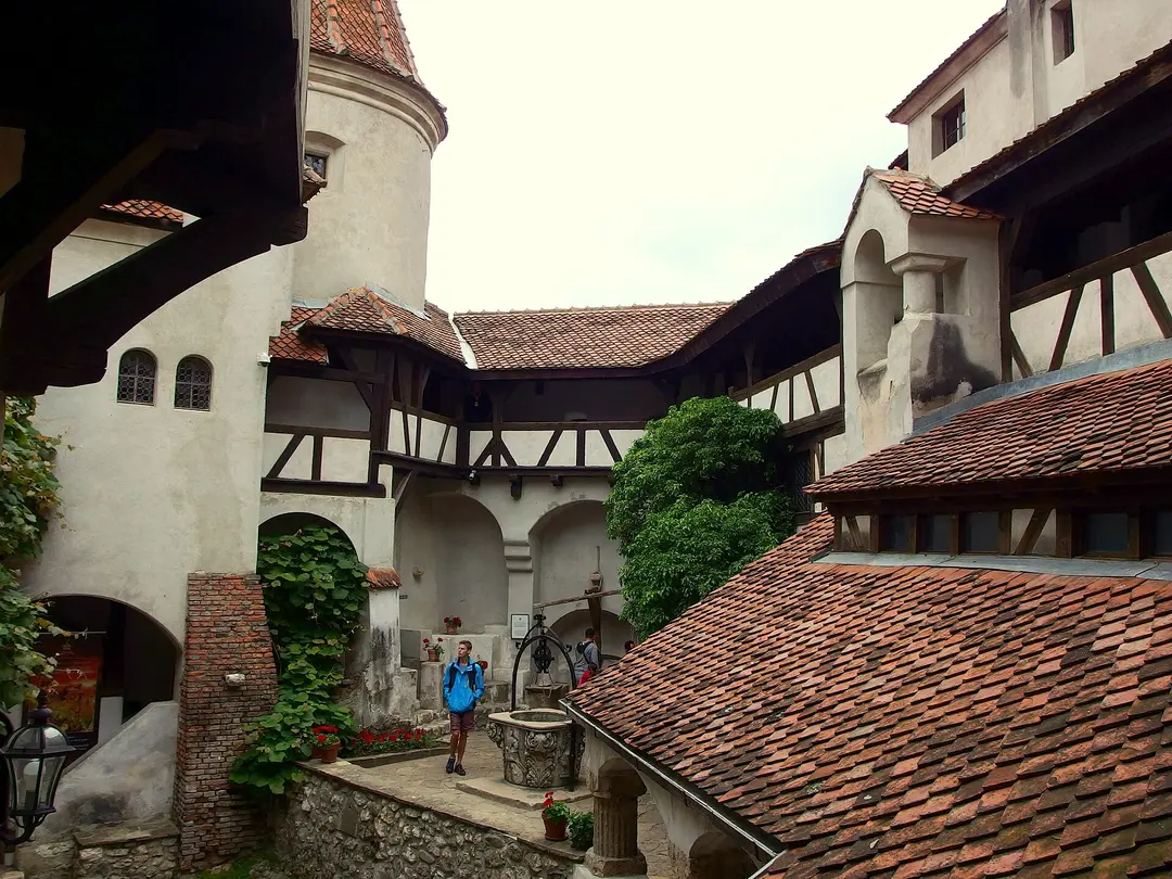 The stone entrance steps of Bran Castle leading up past a faded painted inscription on the wall
