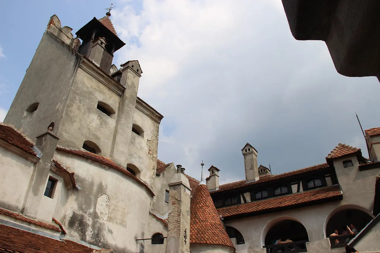 The white and half-timbered inner galleries of Bran Castle with visitors on the balconies