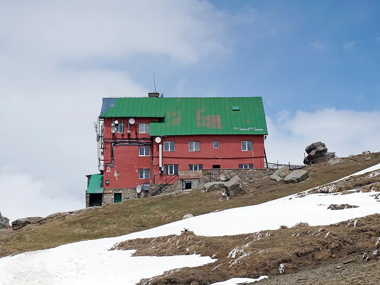 Cabana Babele, the mountain hut near the upper cable-car station on the Bucegi plateau, with hikers on the terrace