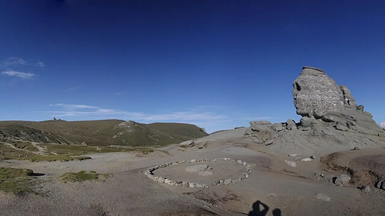 The Bucegi Sphinx, a wind-carved rock formation on the high plateau, seen in profile against a pale sky above the Southern Carpathians