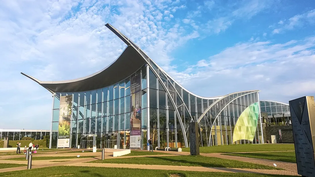 The curved glass and steel dome of Therme Bucharest at Balotesti under a blue sky