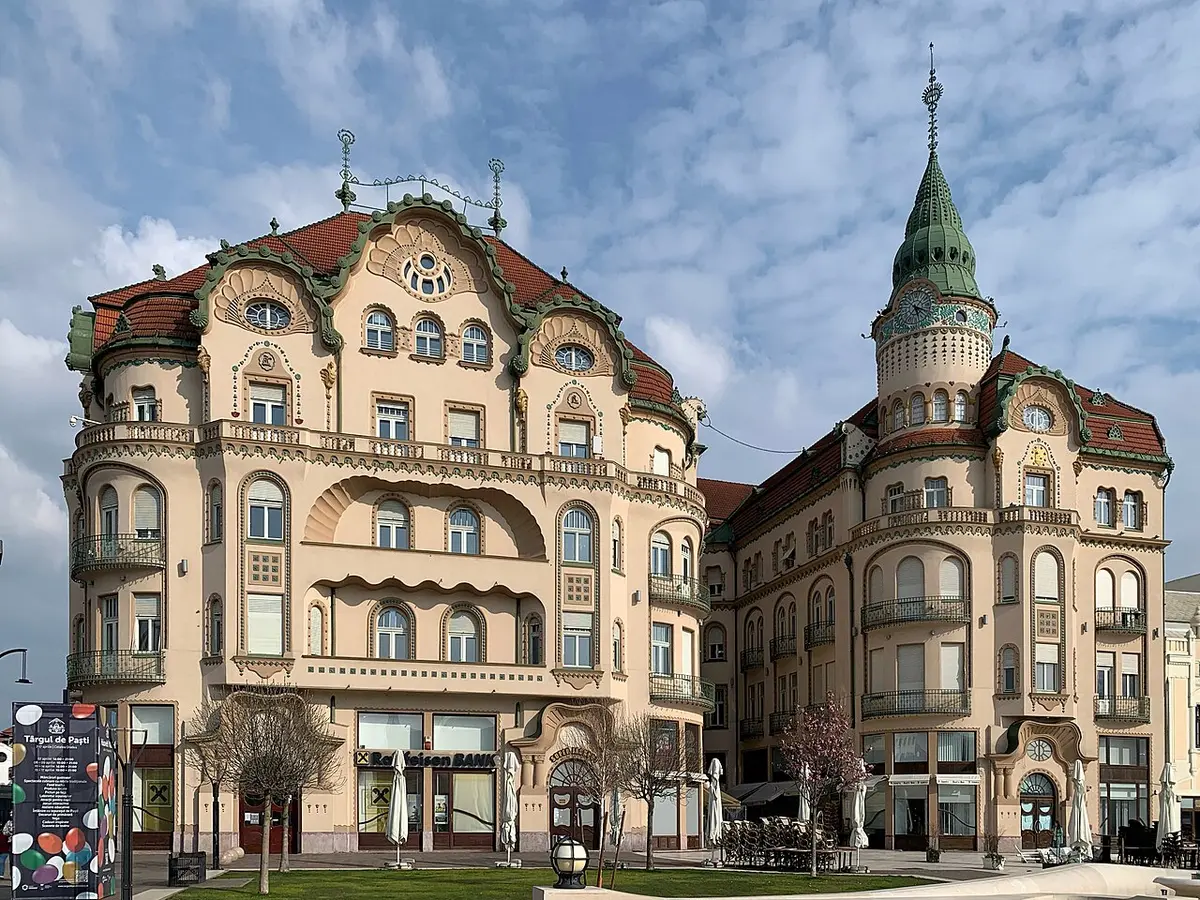 Ornate Art Nouveau facade of the Black Eagle Palace in Oradea with arched windows and pale stonework