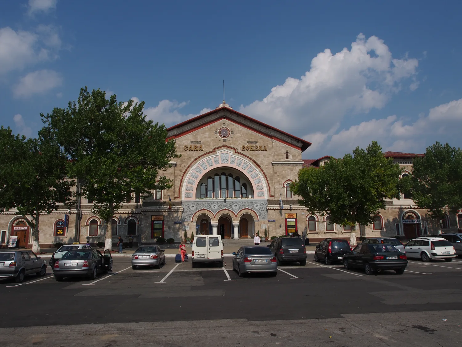 The grand pale-yellow facade of Chisinau railway station with its clock and arched windows, where the Prietenia night train arrives in the morning