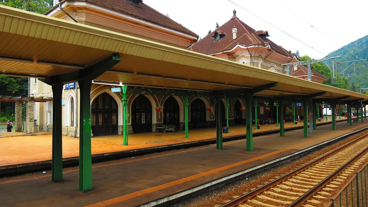 The historic Sinaia railway station facade under a clear sky, the stop for Bucharest day-trip trains to Peles Castle