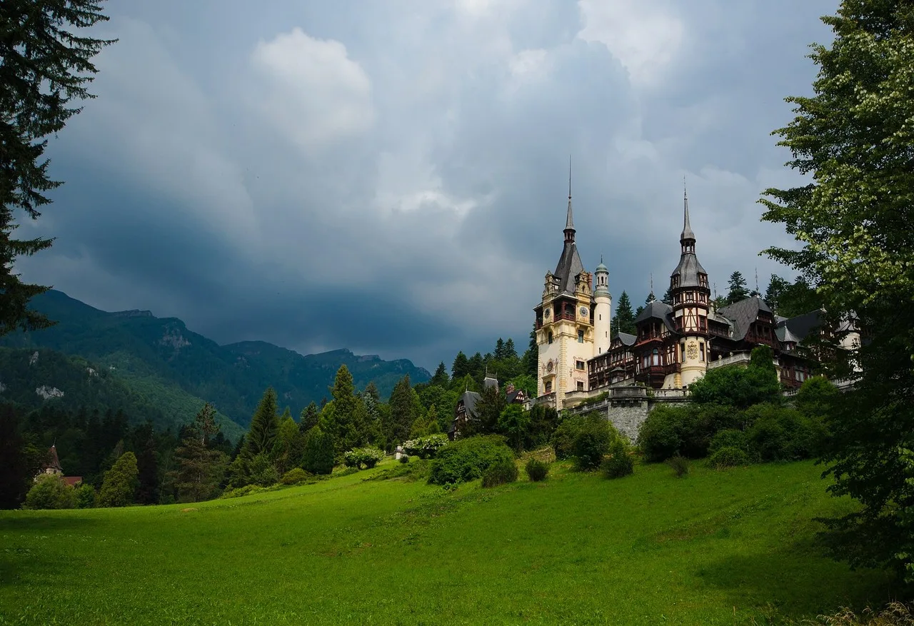 Peles Castle facade and towers against the forested Carpathian slope above Sinaia
