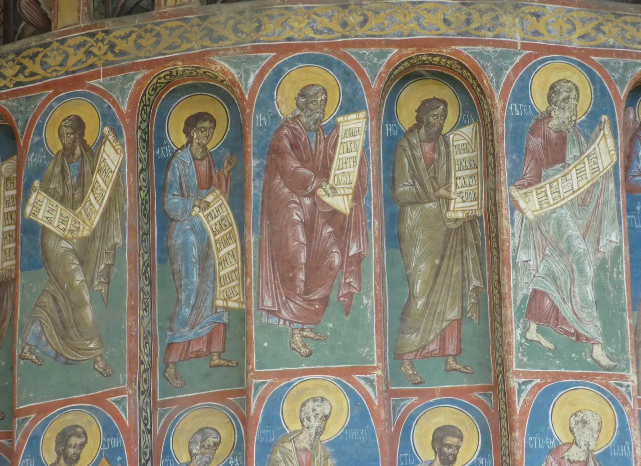 Close-up of Voronet exterior frescoes: rows of prophets in robes painted against a deep blue and green background