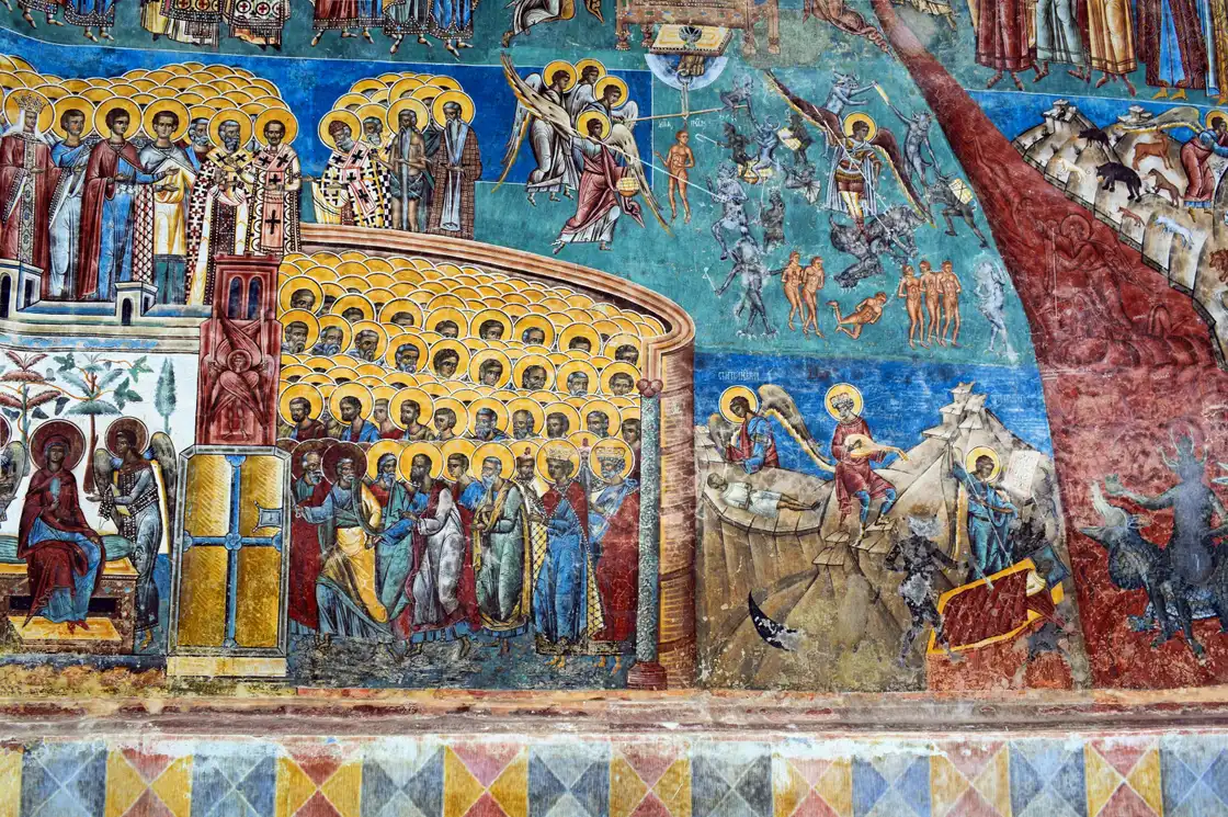 The Last Judgment fresco on the west wall of Voronet: ranks of saints, angels weighing souls, and sinners driven toward a river of fire