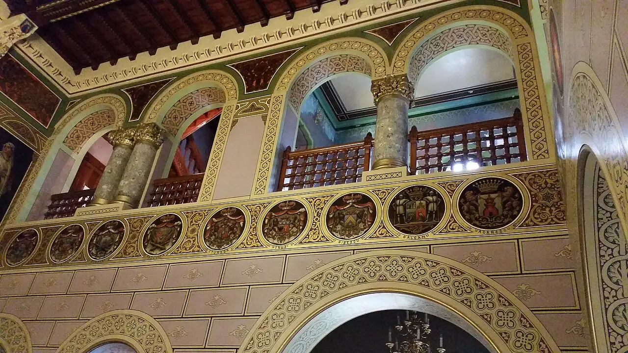 The upper arcade of the Cantacuzino ballroom, a band of gilded circular medallions painted with the coats of arms of families related to the Cantacuzinos
