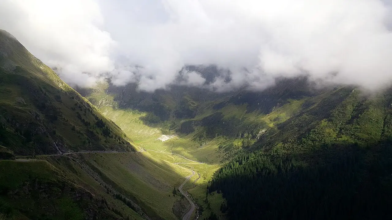 Balea Lake at the top of the Transfagarasan pass, a glacial lake ringed by bare rock ridges, the end point of one of the drives a rental car unlocks