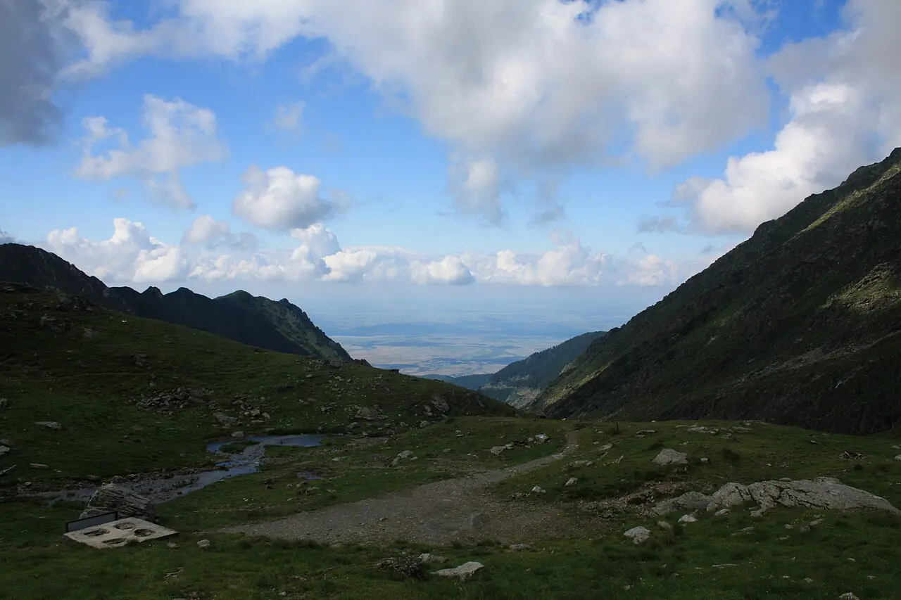 The deep glacial valley below Balea Lake in the Fagaras, green slopes falling away steeply on both sides toward the lowlands