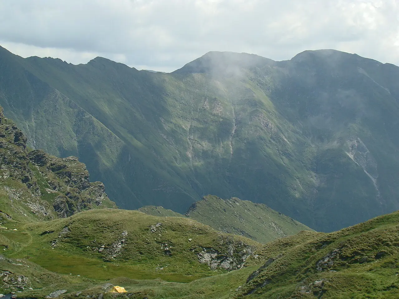 The Arpas ridge of the Fagaras Mountains seen from beside Lake Capra, a glacial lake at 2230m ringed by bare rock and grass