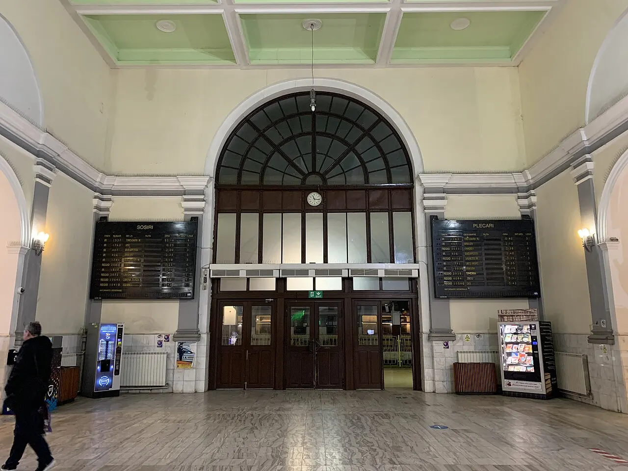 Interior hall of Cluj-Napoca railway station with ticket windows and waiting passengers