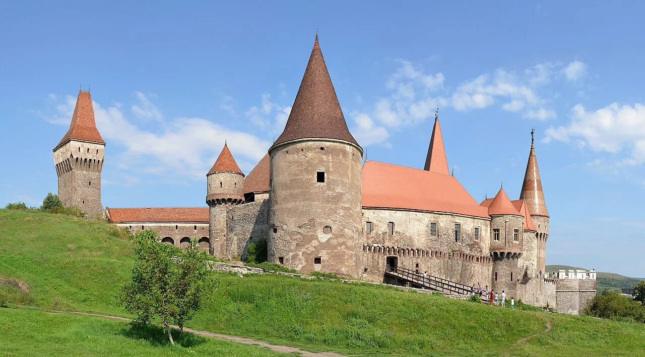 The towers and roofs of Corvin Castle in bright sun, the tall Neboisa keep on the left connected to the main body by a wall
