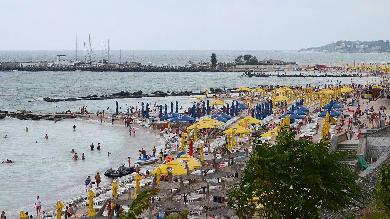 Sandy Black Sea shoreline and low-rise hotels at Eforie Nord under a summer sky