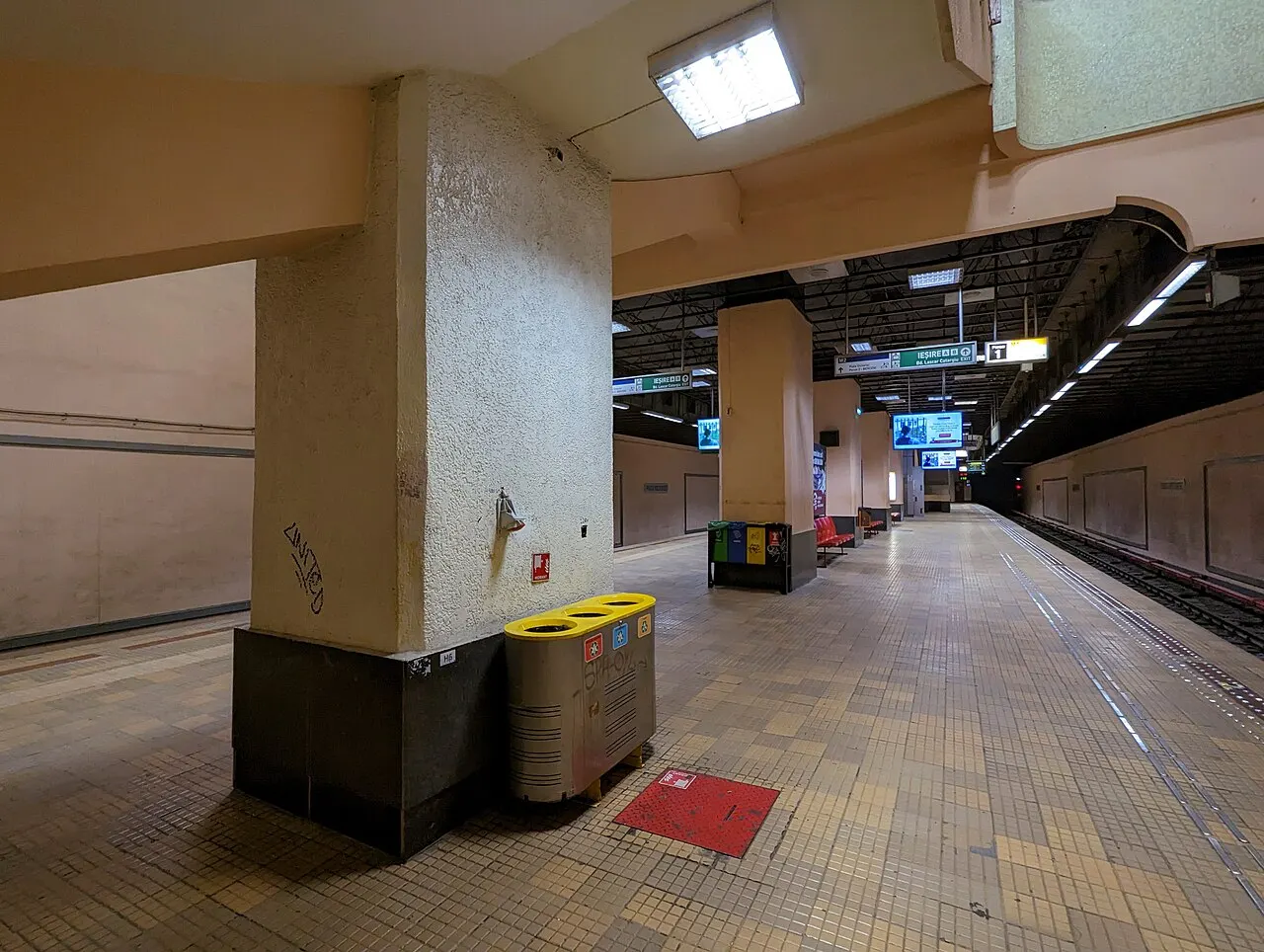 A platform of Piata Victoriei metro station in Bucharest, tiled walls and a train waiting at the platform edge