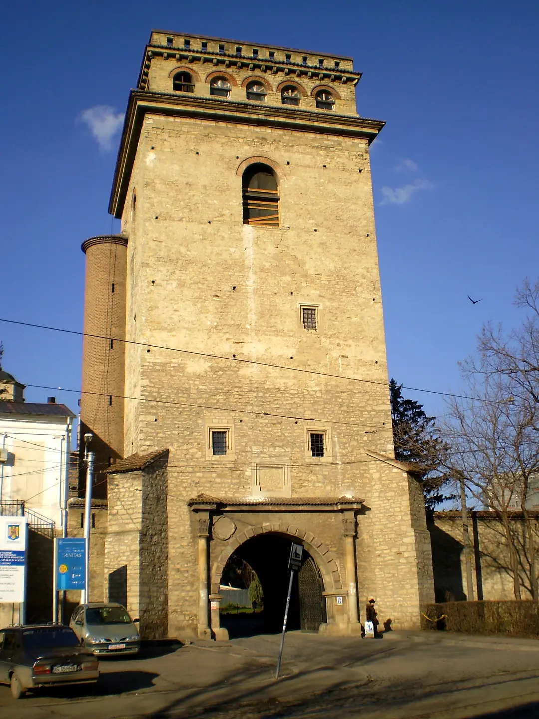 The tall stone gate tower of Golia Monastery in Iasi rising above the enclosure wall against a blue sky