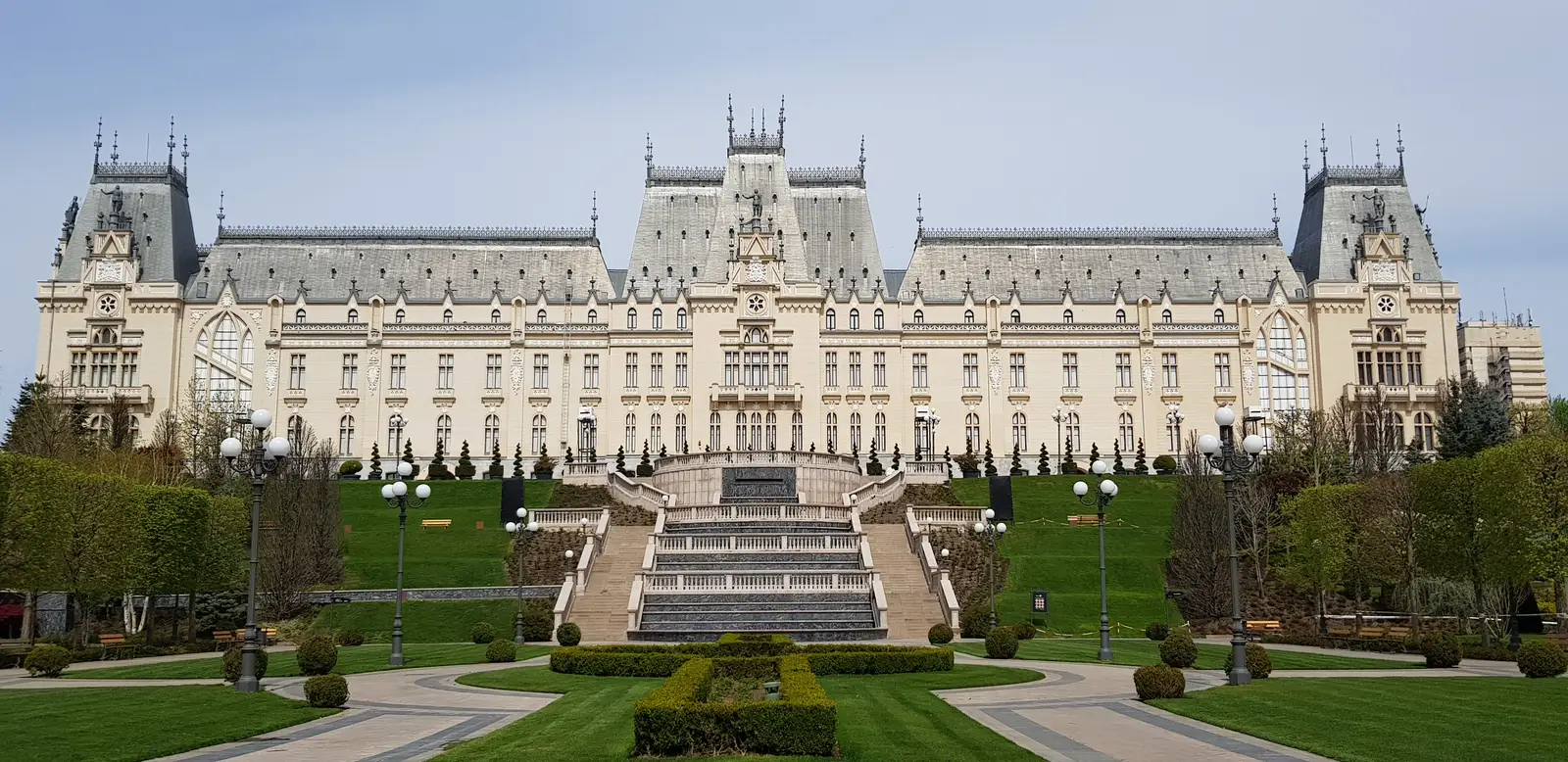 The full Neo-Gothic facade of the Palace of Culture in Iasi seen from the front lawn, symmetrical wings around the central tower