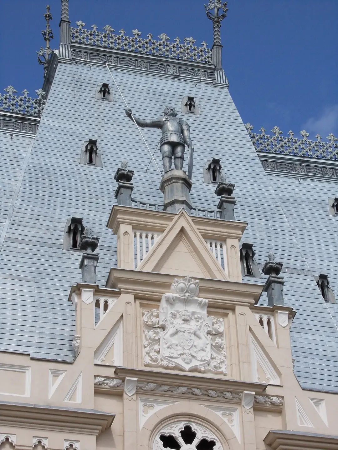 The clock tower of the Palace of Culture in Iasi seen from below, its three faces set against the sky