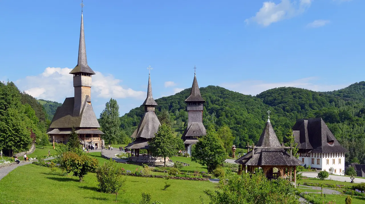 The tall shingled wooden spire of Barsana Monastery rising above its gardens in the Iza valley, Maramures