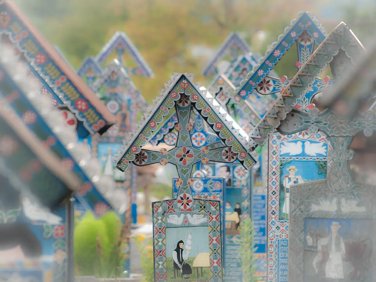 Rows of blue painted wooden crosses with small carved scenes at the Merry Cemetery in Sapanta