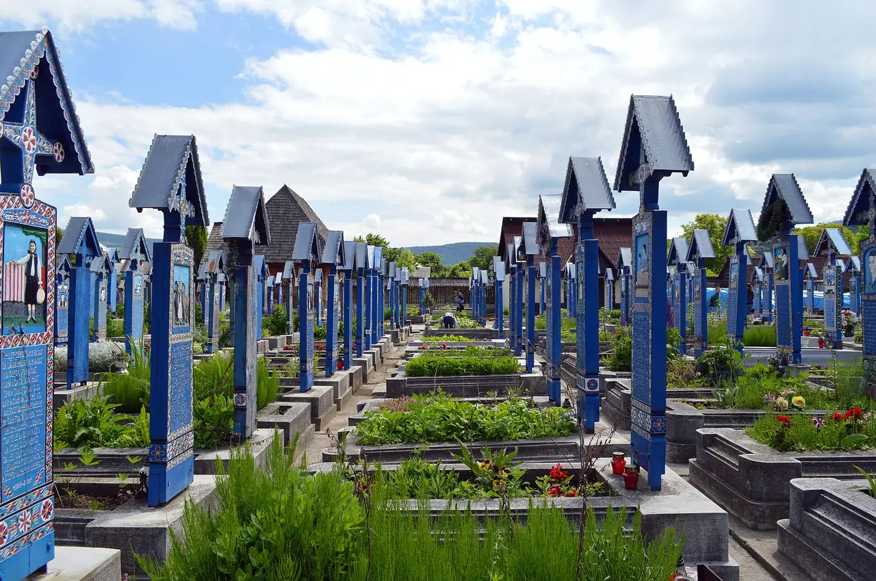 Wide view of the Merry Cemetery in Sapanta, dense rows of blue painted crosses with the wooden church behind