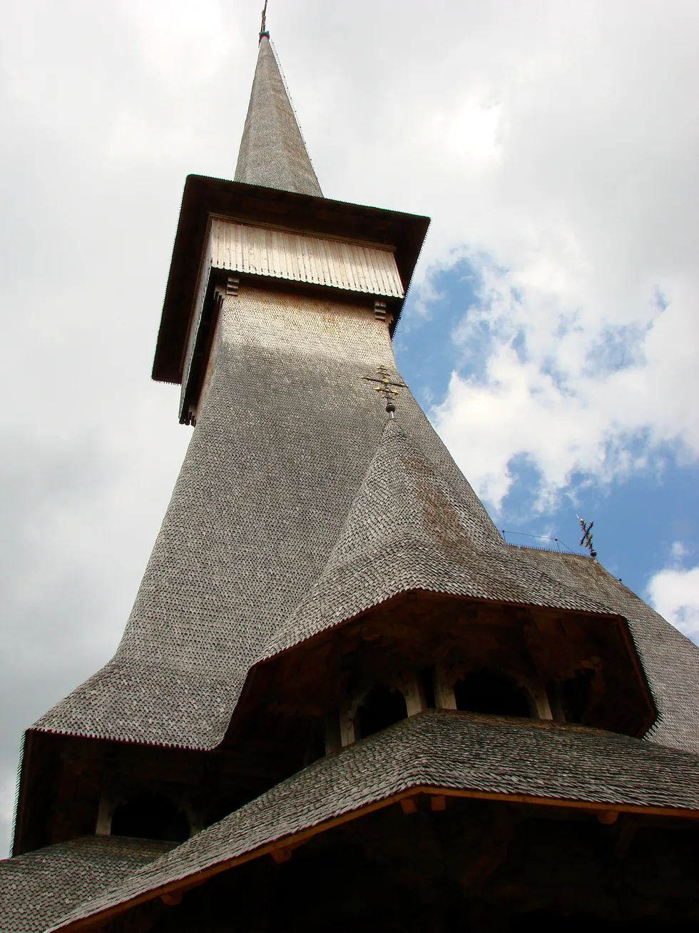A very tall slim wooden church spire at a monastery near Sapanta, in the Maramures timber tradition
