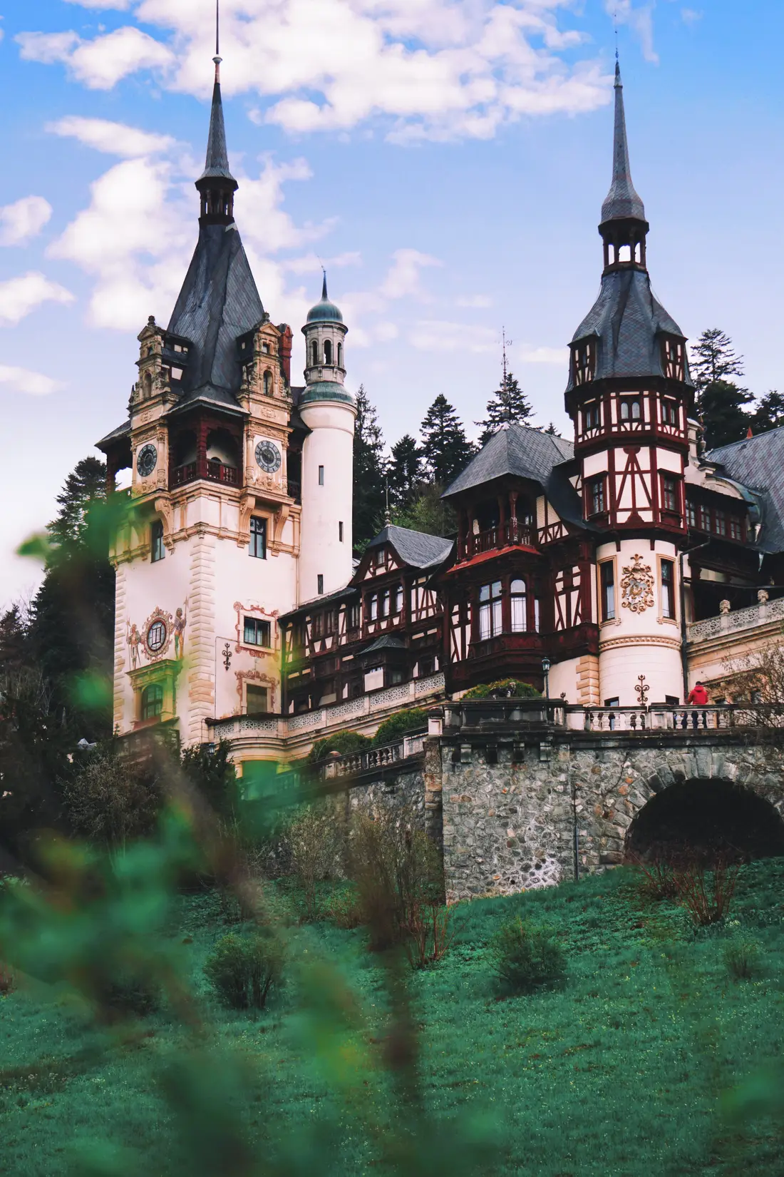 Peles Castle in Sinaia, its half-timbered towers and spires rising against the forested Carpathian slopes