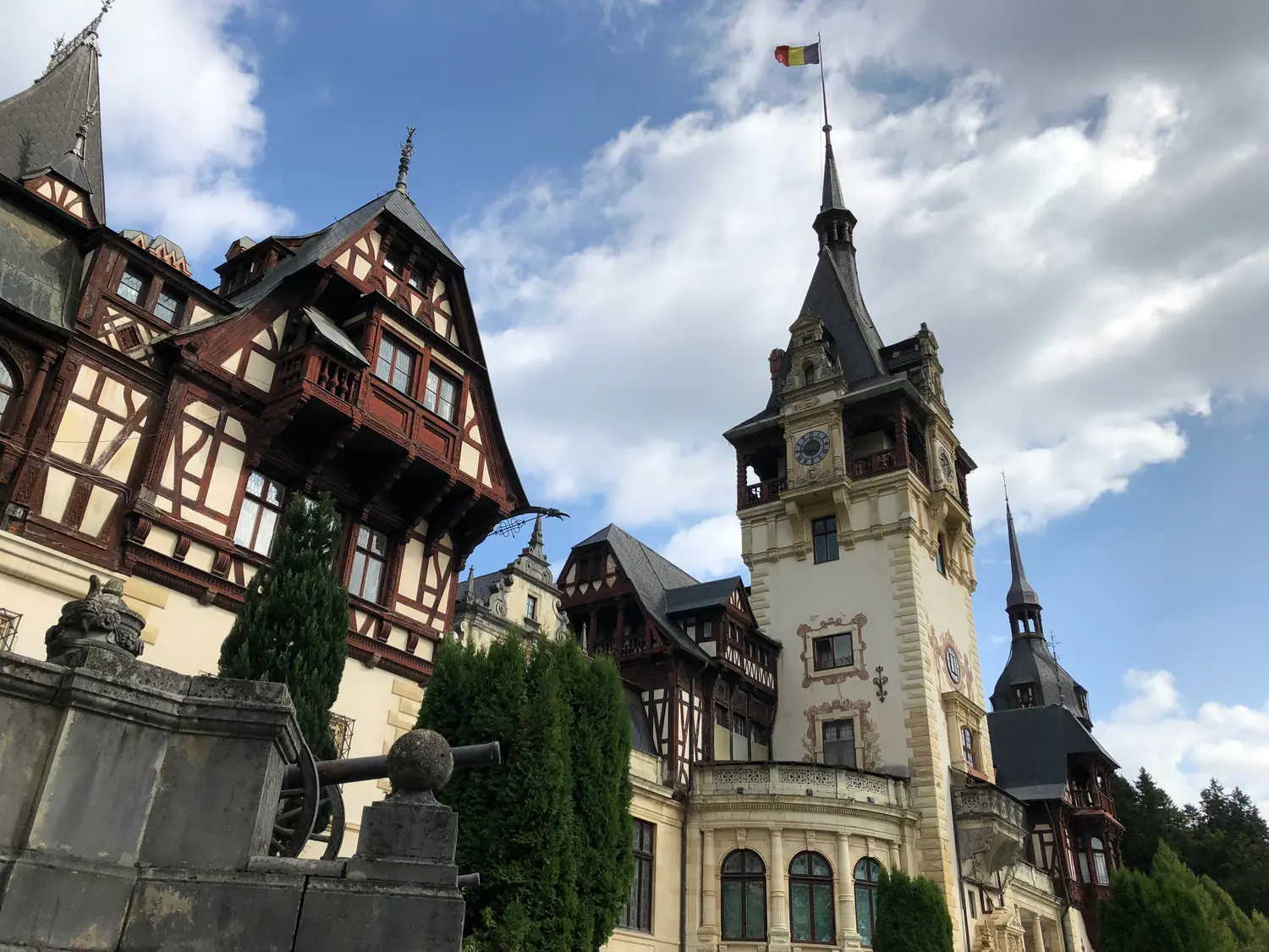 The front terrace of Peles Castle with its ornamental garden, statues and fountain below the facade