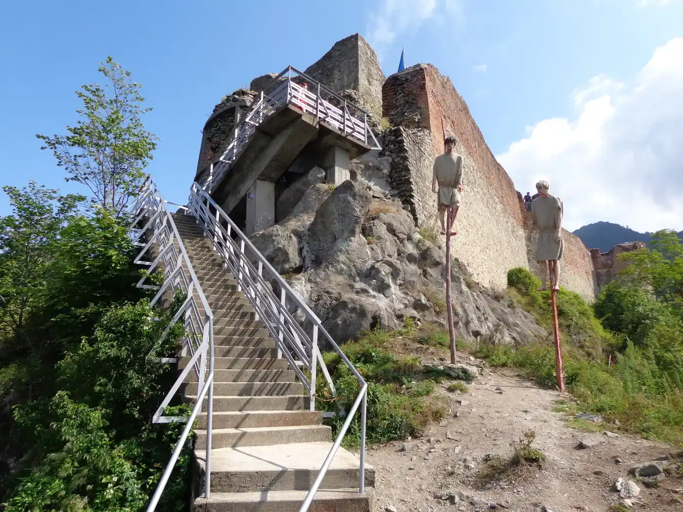Main view of Poenari Castle ruins with stone walls and towers on the forested mountain crest