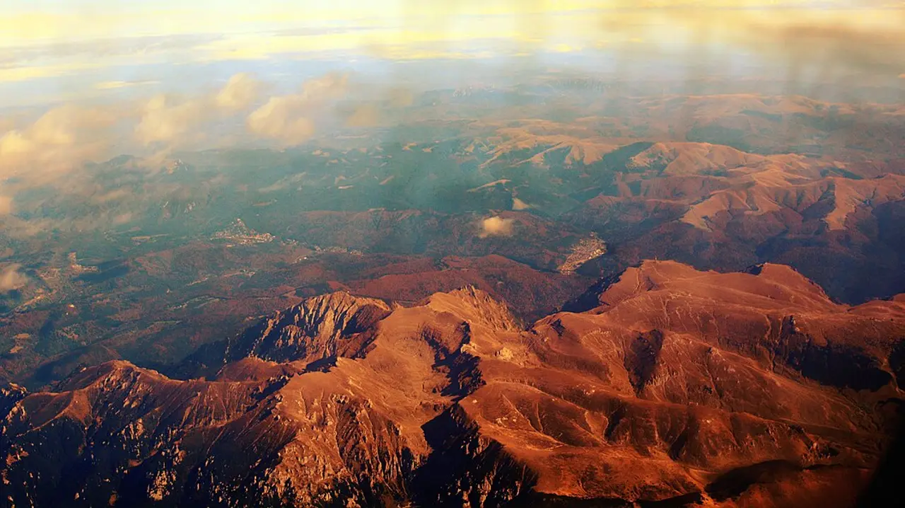 Aerial view of Predeal spread across a forested Carpathian pass with ridges rising on both sides