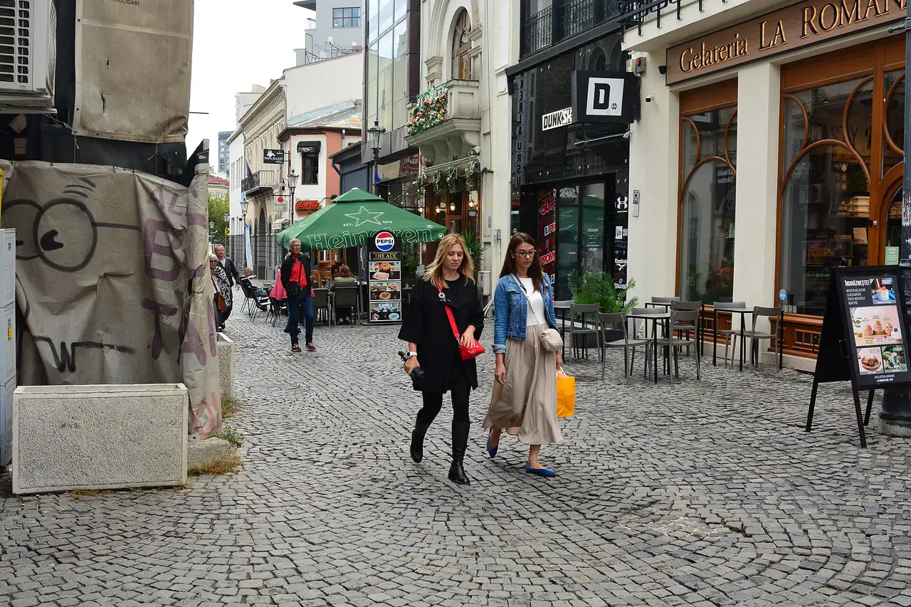 People walking the cobbled Strada Lipscani in the Old Town of Bucharest, lined with cafes and shops
