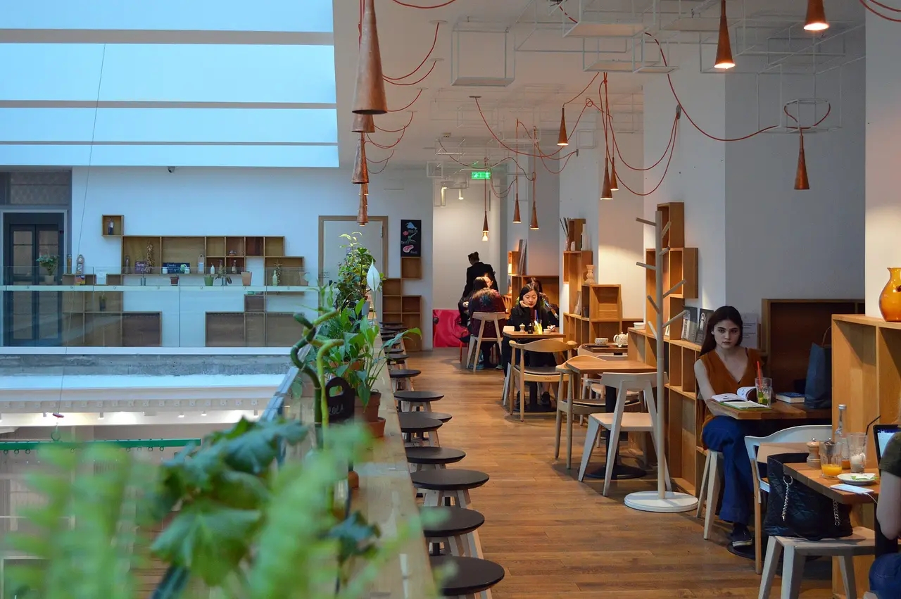 The airy, plant-filled interior of Carturesti Carusel, a bookshop-cafe in Bucharest, with people reading and working at tables