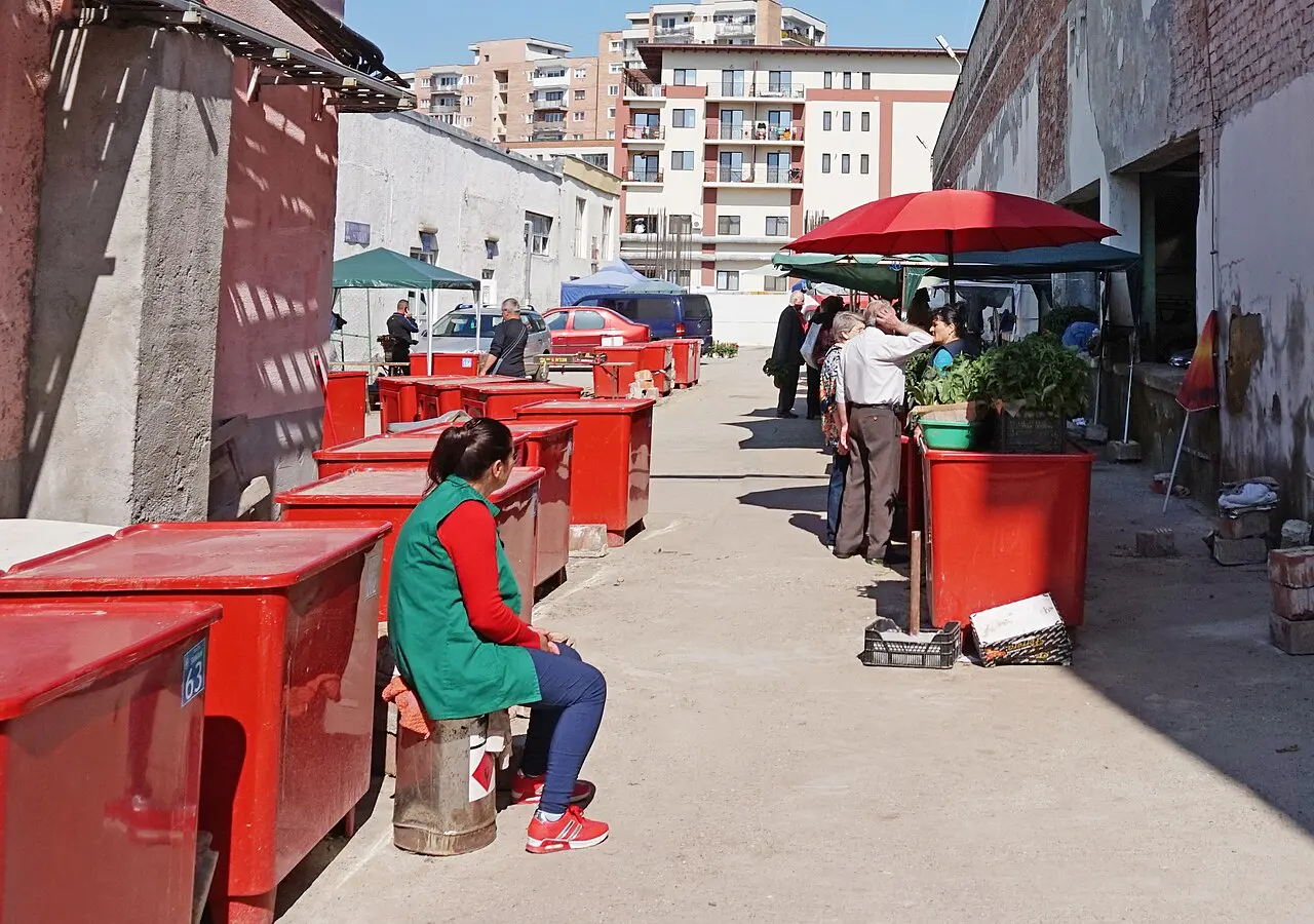 An open-air produce market in Ramnicu Valcea, Romania, with stalls of fruit and vegetables sold in lei