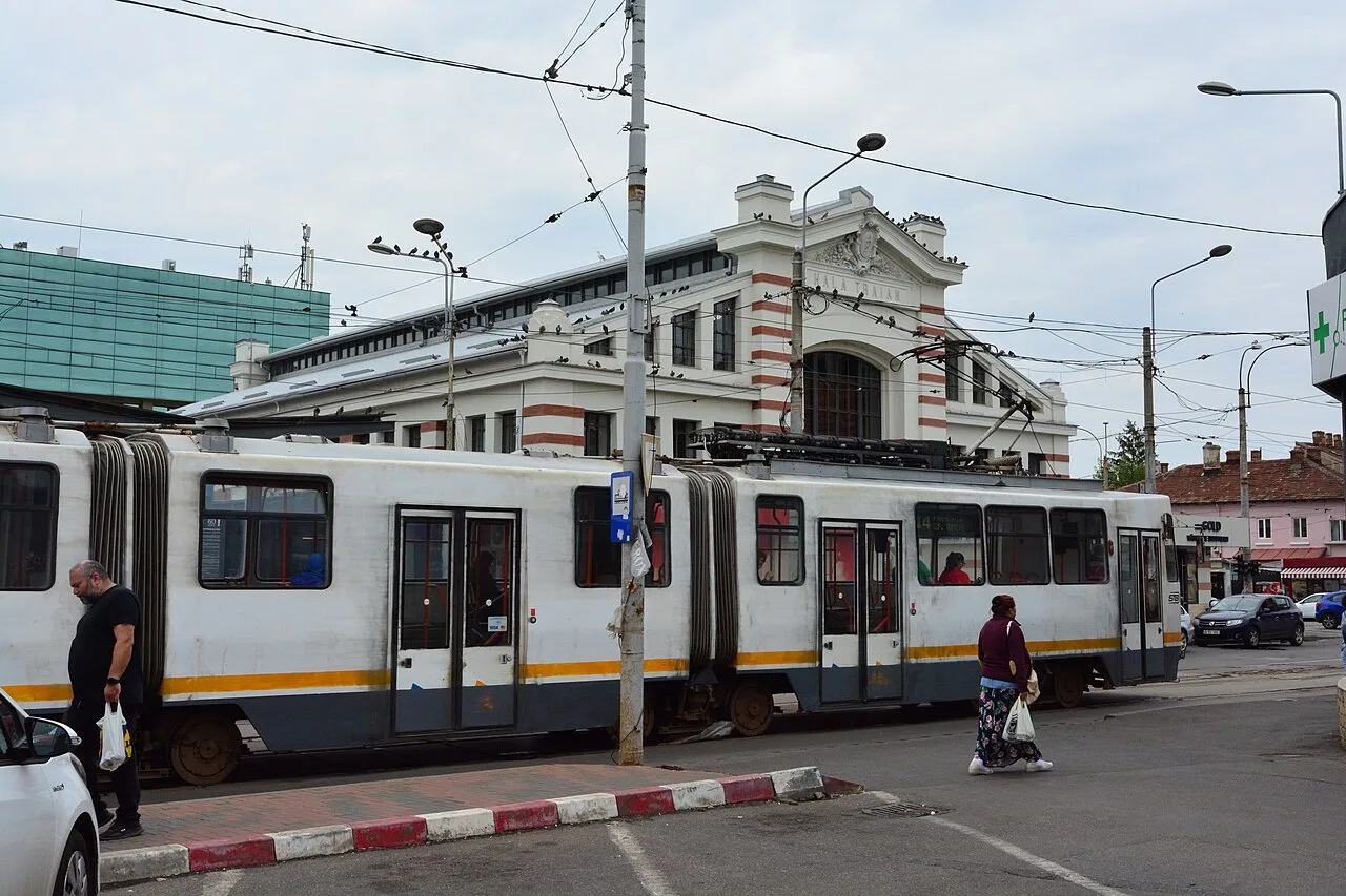 A tram on a Bucharest street in front of Hala Traian, part of the cheap public transport network you tap onto with a contactless card