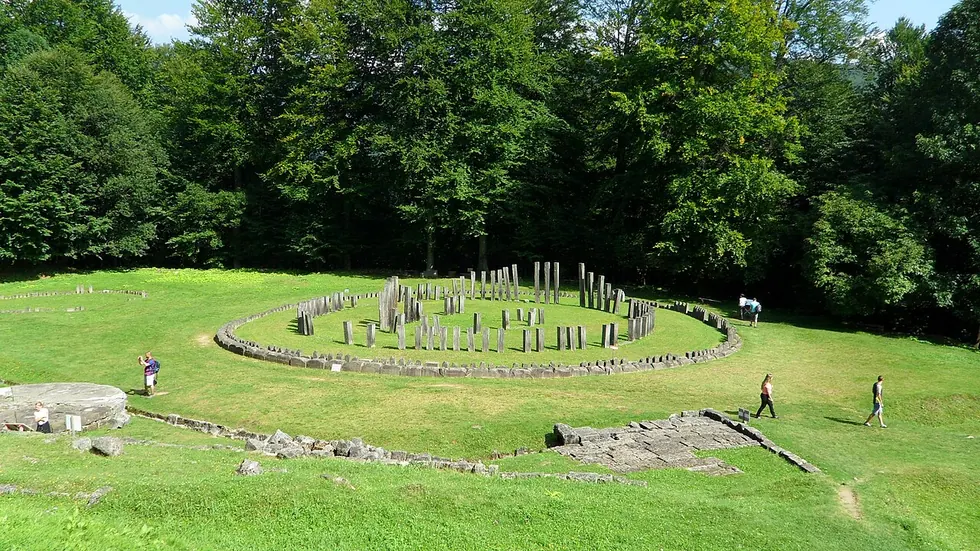 The great circular sanctuary of Sarmizegetusa Regia, rows of low stone and timber post-bases laid out in a ring on a grassy mountain terrace