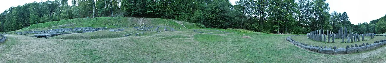 Wide panorama of the sacred zone at Sarmizegetusa Regia, the levelled terrace with temple foundations and forested ridges behind