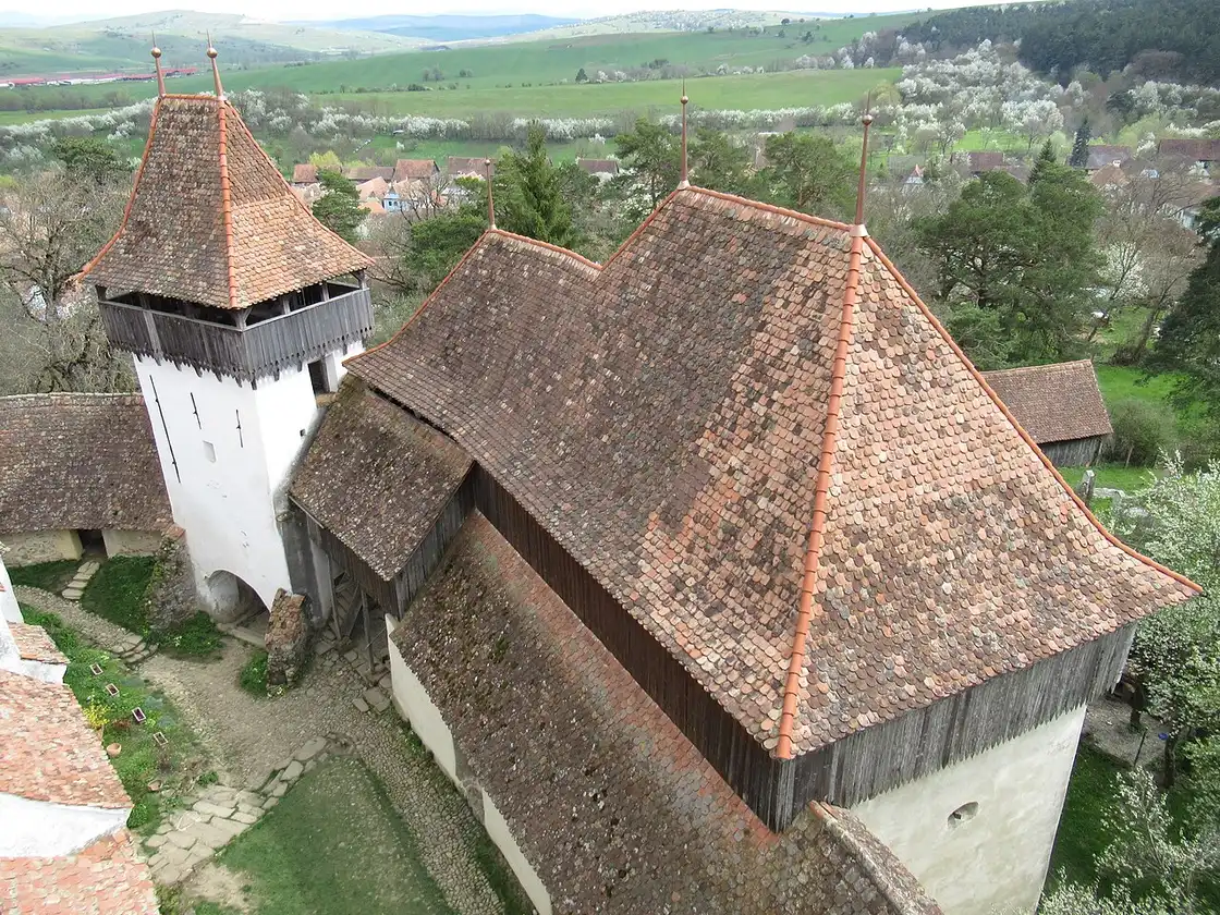 The whitewashed fortified church of Viscri behind its plain defensive walls