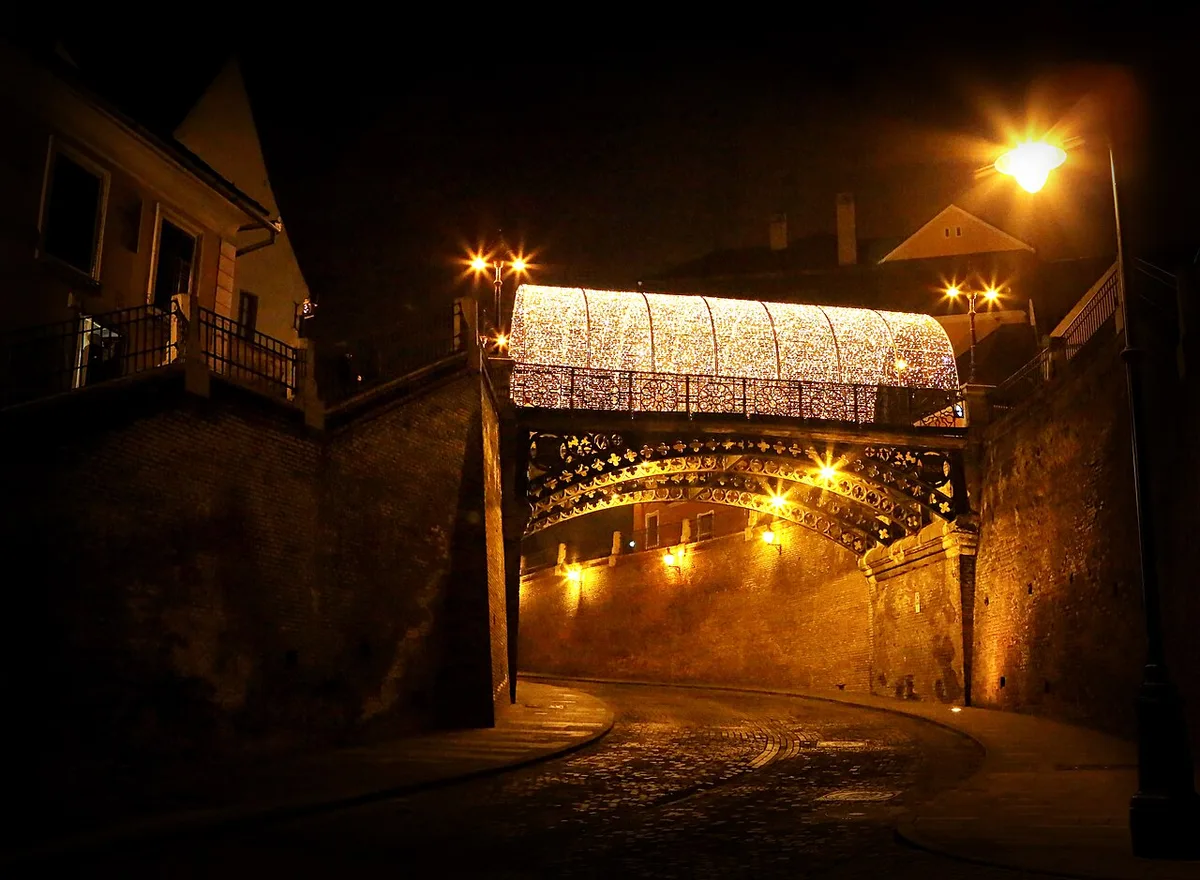 The Bridge of Lies in Sibiu, a small wrought-iron pedestrian bridge with Neo-Gothic arches over a street