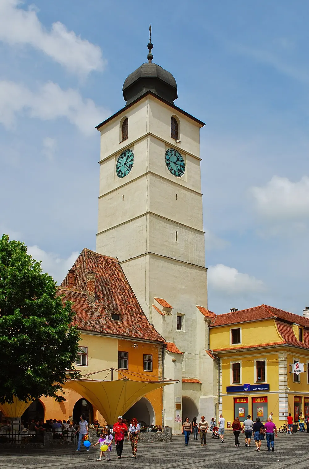 The Council Tower of Sibiu rising between the two squares, a tall stone tower with a steep tiled roof and clock