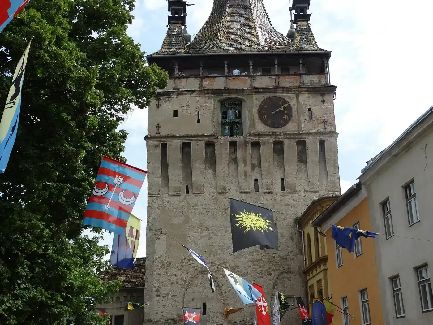 The Clock Tower square during the Sighisoara medieval festival, crowds and market stalls below the tower