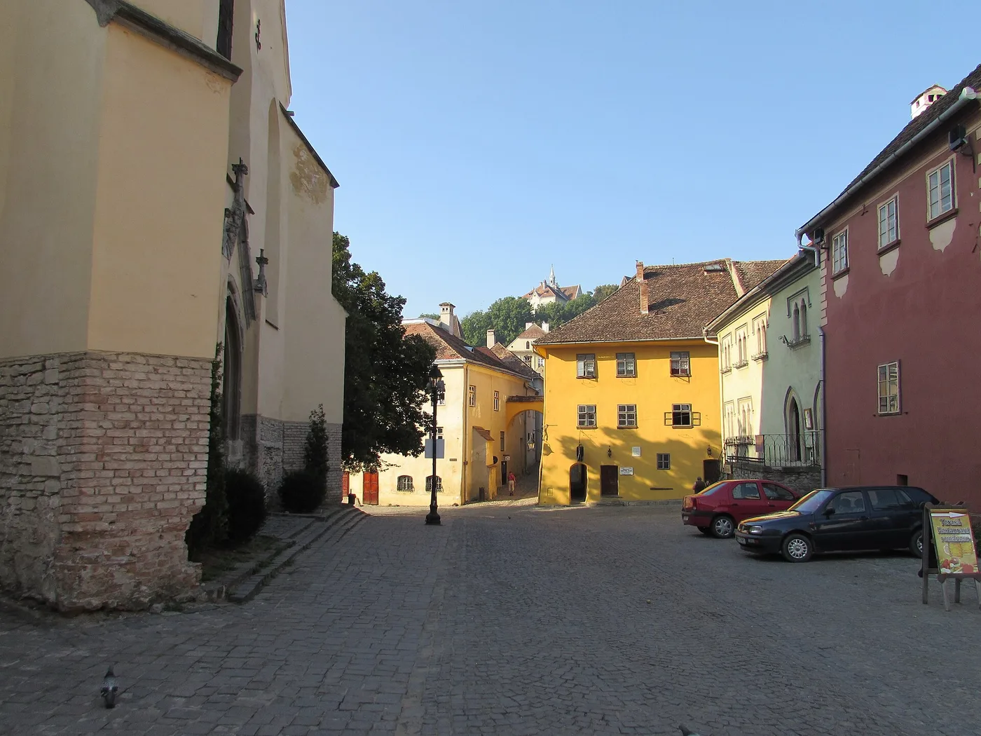 The Museum Square in Sighisoara with the Clock Tower and colourful guild houses around the cobbles