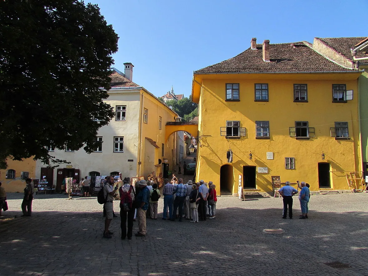 Casa Vlad Dracul on the Sighisoara citadel square, an ochre medieval house with a wrought-iron dragon sign