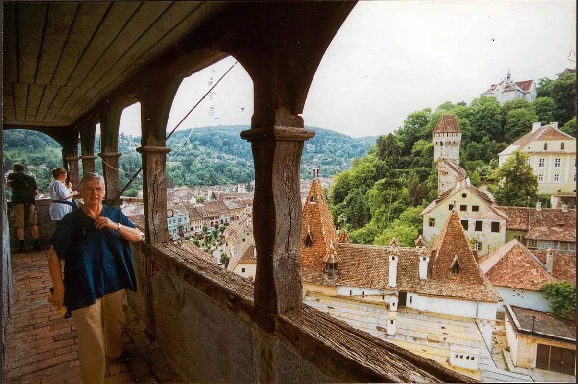 The wooden viewing gallery at the top of the Sighisoara Clock Tower looking out over red roofs and green hills