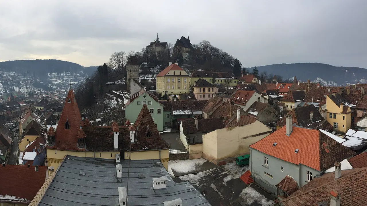 The tiled roofs of the Sighisoara citadel with the Church on the Hill above, seen on a grey winter day