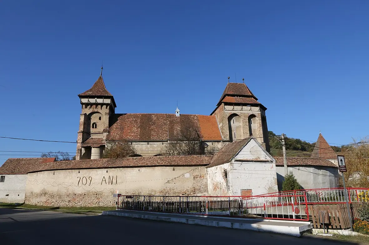 The fortified evangelical church of Valea Viilor behind its defensive walls, seen from the village